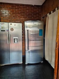 Er staan twee koelkasten naast een bakstenen muur. bij GB Hostel IG in Puerto Iguazú