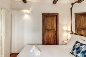 a bedroom with a white bed and a mirror at MAYA RHOME TRASTEVERE in Rome