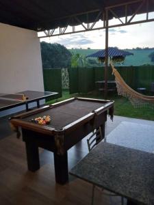 a pool table in a room with a hammock at casa com bela vista em Bragança Paulista in Bragança Paulista
