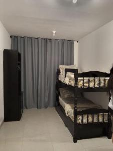 um quarto com três beliches e uma cortina em casa com bela vista em Bragança Paulista em Bragança Paulista