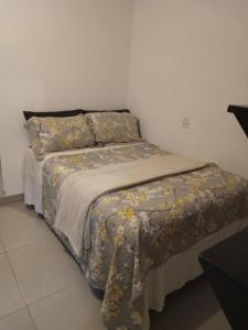 uma cama com um cobertor e almofadas em casa com bela vista em Bragança Paulista em Bragança Paulista
