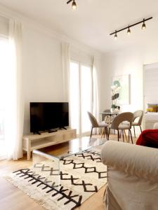 een woonkamer met een tv en een bank bij Encantador Alojamiento junto al corazón de Madrid Río in Madrid