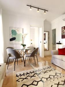 een woonkamer met een tafel en stoelen bij Encantador Alojamiento junto al corazón de Madrid Río in Madrid