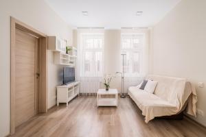 a white living room with a couch and a tv at Bright 73m2 Apartment - Blaumana Street Central in Riga