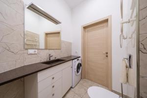 a bathroom with a sink and a washing machine at Bright 73m2 Apartment - Blaumana Street Central in Riga +18 photos