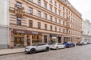 a row of cars parked in front of a building at Bright 73m2 Apartment - Blaumana Street Central in Riga