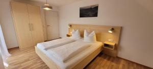 een slaapkamer met een bed met witte lakens en kussens bij Ferienhof Fischer in Seebach