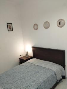 una camera con un letto e un comodino e due orologi a muro di ENASTRON a Olympos