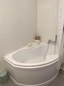 - białą wannę w białej łazience w obiekcie Aida Apartman Siófok w Siófoku +10 zdjęć