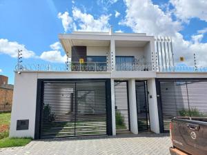 a white house with two garage doors and a car at apto. moderno, perto faculdades ulbra e católica. in Palmas