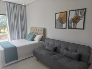 ein Schlafzimmer mit einem Bett und einer Couch in der Unterkunft apto. moderno, perto faculdades ulbra e católica. in Palmas