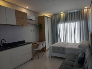 1 dormitorio con cama, escritorio y cocina en apto. moderno, perto faculdades ulbra e católica., en Palmas