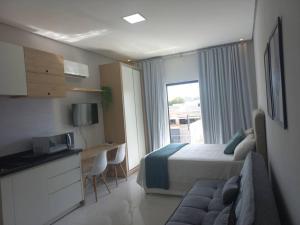 Habitación de hotel con cama, escritorio y ventana en apto. moderno, perto faculdades ulbra e católica., en Palmas