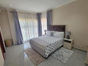 a bedroom with a bed and a large window at Sable Suites B1, 1 Bed Apartments in Kabulonga in Lusaka +25 photos