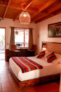 a bedroom with a large bed and a table at Tambo Atacama Lodge in San Pedro de Atacama
