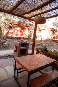 a porch with a hammock and a bench and a table at Tambo Atacama Lodge in San Pedro de Atacama