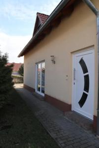 ein weißes Haus mit einer Tür mit schwarzem Halbmond in der Unterkunft Ferienwohnung Gundermann in Quedlinburg