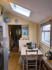 a kitchen with a table with chairs and a window at Cosy London single room (near Wimbledon) in London