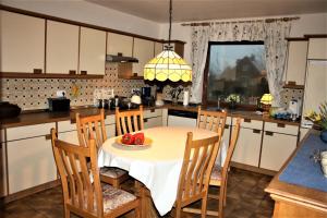 eine Küche mit einem Tisch, auf dem eine Schüssel Tomaten steht in der Unterkunft Haus Halligblick, Ferienwohnungen am Wattenmeer, WhgHooge in Dagebüll