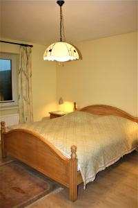 ein Schlafzimmer mit einem Holzbett und einer Lampe in der Unterkunft Haus Halligblick, Ferienwohnungen am Wattenmeer, WhgHooge in Dagebüll