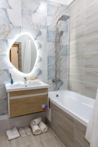 a bathroom with a tub and a sink and a mirror at Astana arena ЖК Бухар Жырау in Taldykolʼ