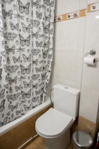 een badkamer met een toilet en een douchegordijn met vlinders bij Peraia Deluxe Apartment in Perea