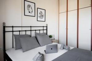 een slaapkamer met een bed met een laptop erop bij Peraia Deluxe Apartment in Perea