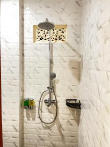 a shower with a shower head in a bathroom at Pala House in Ubud