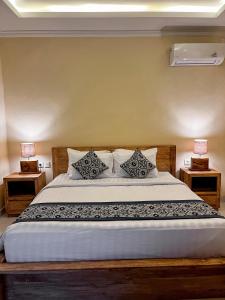 a bedroom with a large bed with two night stands at Pala House in Ubud