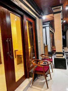 two chairs and a table in a room at Pala House in Ubud