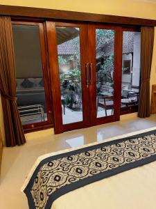 a bedroom with a large glass window and a bed at Pala House in Ubud