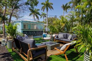 a patio with couches and chairs in front of a house at Captain Ed's - Charming Studio at PalmView of Sanibel with Bikes in Sanibel