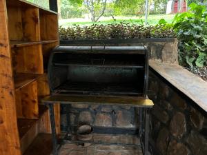 an outdoor grill with a bench on a brick wall at Muhazi View Resort in Muhazi