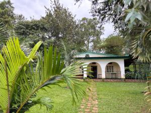 Muhazi的住宿－Muhazi View Resort，一座白色的小房子,设有绿色屋顶