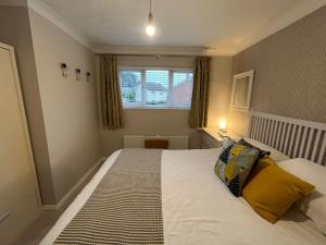 a bedroom with a large white bed with yellow pillows at Tarporley No 7 in Tarporley
