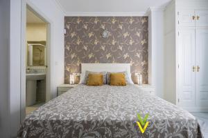 - une chambre avec un grand lit et des oreillers jaunes dans l'établissement Vitvi Fuengirola - Chinorros Centro, à Fuengirola