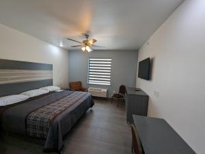 - une chambre avec un lit et un ventilateur de plafond dans l'établissement Texas Bungalows Hotel and Hotel Que, à Pflugerville