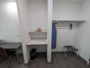 a closet with white shelves and a blue tie at Texas Bungalows Hotel and Hotel Que in Pflugerville