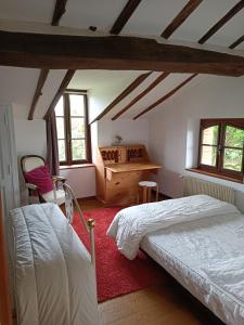 Schlafzimmer mit einem Bett, einem Schreibtisch und Fenstern in der Unterkunft Domaine des Pindouls 