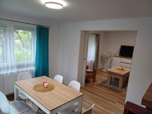 a living room with a table and chairs and a dining room at Domek Zacisze in Laskowa