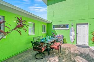 a green walled patio with a table and chairs at Luxury Suite| Beach| Fishing| Dock in St Pete Beach