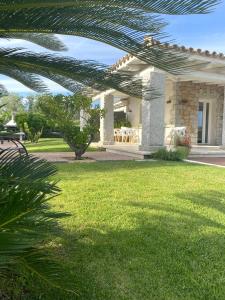 a house with a patio and a grass yard at Destino di Nora in Pula
