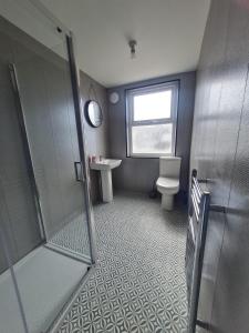 a bathroom with a shower and a toilet and a window at Cozy 6 Bedroom HMO in Eston