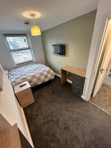 a small room with a bed and a desk at Cozy 6 Bedroom HMO in Eston
