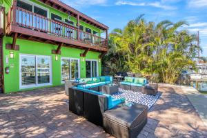 a house with a patio with furniture and a balcony at Luxury Suite| Beach| Fishing| Dock in St. Pete Beach