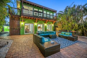 a house with a patio with blue couches at Luxury Suite| Beach| Fishing| Dock in St. Pete Beach