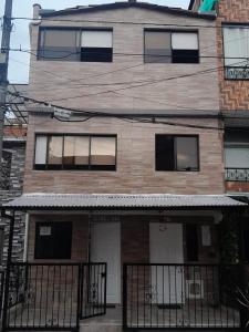 een bakstenen gebouw met een hek ervoor bij El Noral in Medellín