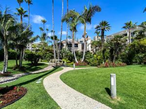 a walkway in front of a house with palm trees at Seaside Cottage in Oceanside
