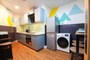 een keuken met een koelkast en een wasmachine bij E101 Urban chic loft in Coventry
