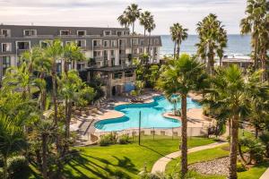 an aerial view of a resort with a pool and palm trees at Seaside Cottage in Oceanside